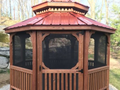 12' Octagon Wood, Standard Rails, Straight Fascia, No Top Rails, Pagoda Roof, Red Metal Roof, Screen Package, Cedar Stain